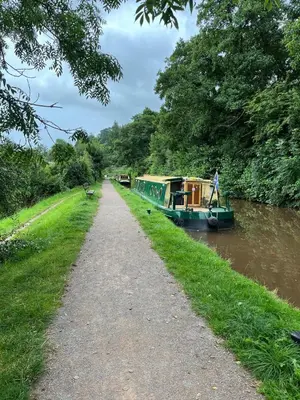 a boat on a river next to a path at Ty Sycamore in Talybont