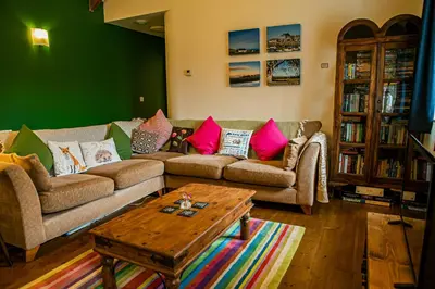 a living room with two couches and a coffee table at Cwt Mochyn Aberaeron in Cross Inn