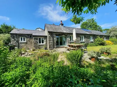 a stone house with a table in front of it at Cwt Mochyn Aberaeron in Cross Inn