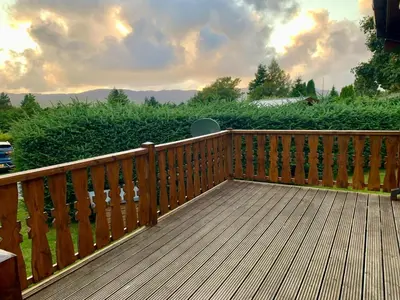 a wooden deck with a view of a field at Caban Marjie in Trawsfynydd