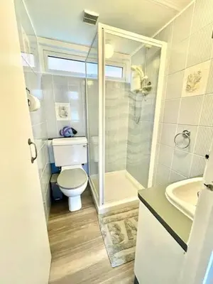 a bathroom with a toilet and a shower and a sink at Chalet 7 Erw Porthor in Tywyn