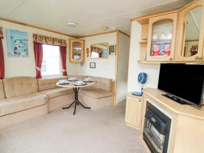 a caravan living room with a couch and a table at D12 Treetops in Aberystwyth