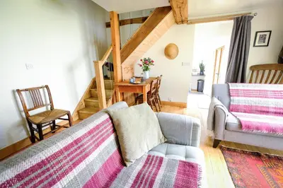 a living room with a couch and a table at Rhyd Y Geifr, Cosy Barn Conversion in Maerdy in Corwen