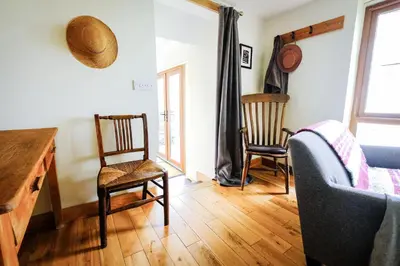 a living room with two chairs and a desk at Rhyd Y Geifr, Cosy Barn Conversion in Maerdy in Corwen