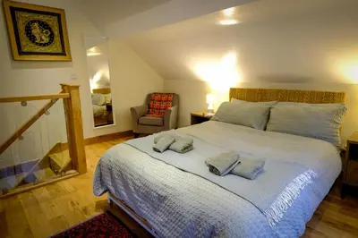a bedroom with a large bed with towels on it at Rhyd Y Geifr, Cosy Barn Conversion in Maerdy in Corwen