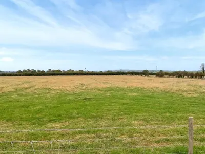 a field with a fence in the middle of a field at Myfanwy in Ciliau-Aeron
