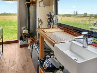 a kitchen with a sink and a counter with a window at Myfanwy in Ciliau-Aeron