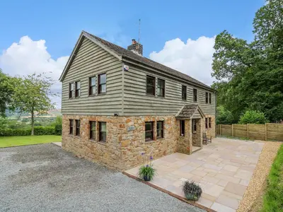 a large stone house with a courtyard in front of it at Oak Apple Cottage in Presteigne