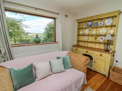 a living room with a couch and a window at Oak Apple Cottage in Presteigne