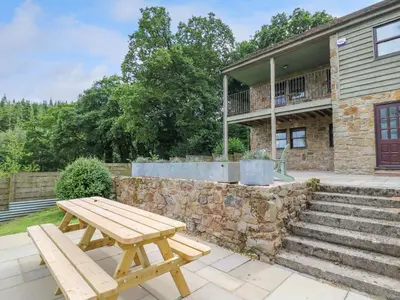 a wooden picnic table in front of a building at Oak Apple Cottage in Presteigne