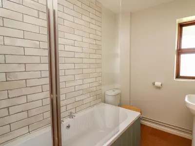 a white bathroom with a tub and a sink at Oak Apple Cottage in Presteigne