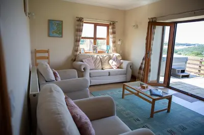 a living room with two couches and a table at Aberystwyth Dinas Cottage in Llanilar