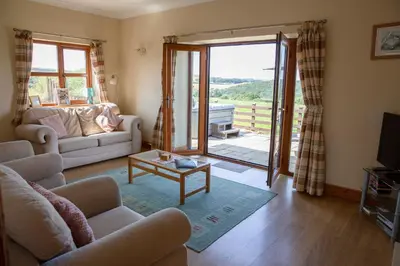 a living room with a couch and a table at Aberystwyth Dinas Cottage in Llanilar