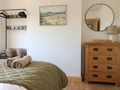a bedroom with a bed with a mirror and a dresser at Bryn Bras in Corwen