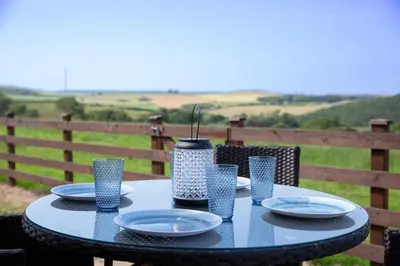 a blue table with plates and a vase on it at Aberystwyth Enlli Cottage in Llanilar