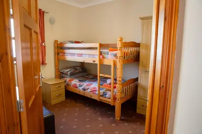 a bedroom with two bunk beds and a closet at Aberystwyth Enlli Cottage in Llanilar