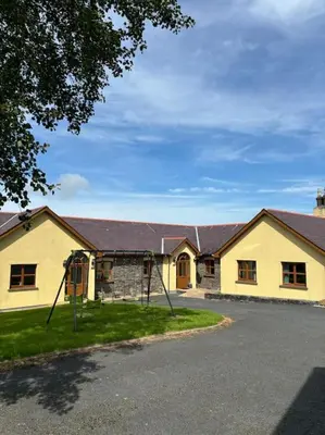 a yellow building with a playground in front of it at Aberystwyth Enlli Cottage in Llanilar