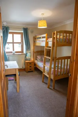a bedroom with two bunk beds and a desk at Aberystwyth Cottage Ilar in Llanilar
