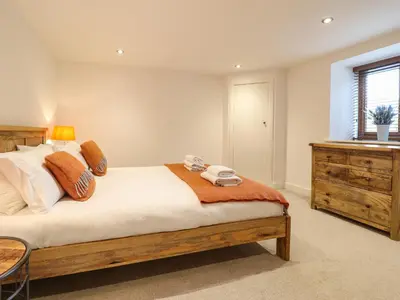 a bedroom with a bed with a dresser and a window at The Granary in Montgomery