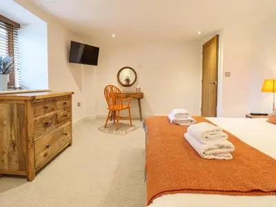 a bedroom with a bed and a wooden dresser at The Granary in Montgomery