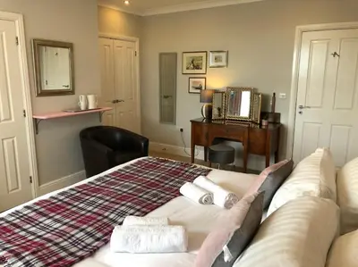 a bedroom with a bed with two towels on it at Cartref Guesthouse - Room 1 Ensuite in Aberdyfi