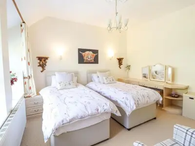 a bedroom with two beds and a mirror at Bryn Glasfor in Barmouth