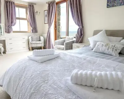 a bedroom with a large bed with two pillows on it at Bryn Glasfor in Barmouth