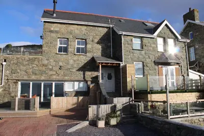 a large stone house with a white door at Bryn Glasfor in Barmouth