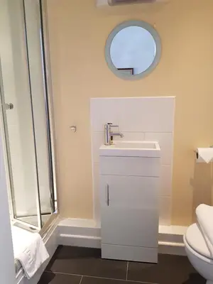 a bathroom with a sink and a toilet and a mirror at Ty Helyg Guest House in Brecon