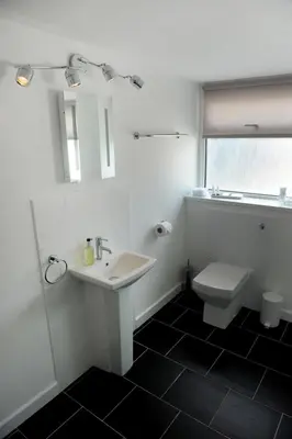 a white bathroom with a sink and a toilet at Ty Helyg Guest House in Brecon
