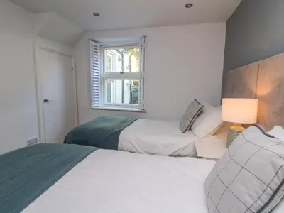 a bedroom with two beds and a window at 1 Gibraltar Terrace in Aberdyfi