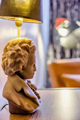 a statue of a child sitting on a table under a lamp at Beautiful Town Centre Apartment 110 Square Metre With Parking WEEKLY and MONTHLY Reduced Rates in Shrewsbury