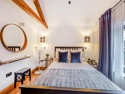 a bedroom with a large bed with blue pillows at The Oaks in Llangollen