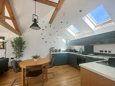 a kitchen with a table and a clock on the wall at The Oaks in Llangollen