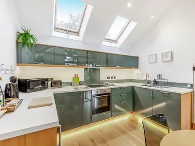 a large kitchen with stainless steel appliances and windows at The Oaks in Llangollen