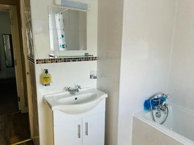 a bathroom with a sink and a bath tub at Snowdonia coastal getaway ideal for groups up to 6 in Llwyngwril