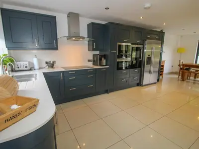 a kitchen with blue cabinets and a tile floor at Timberdyne in Ludlow