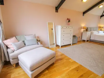 a living room with a couch and a bedroom at Timberdyne in Ludlow
