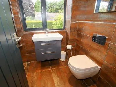 a bathroom with a toilet and a window at Timberdyne in Ludlow