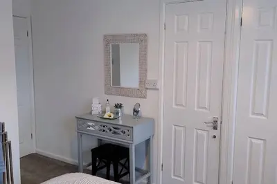 a bathroom with a table and a mirror and a door at Ludlow Mews Town House with Free parking in Ludlow