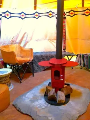 a room with a red stove in a room at Mellow Mountain Eco Retreat Wales Hot-Tub Sauna in Glyn-Ceiriog