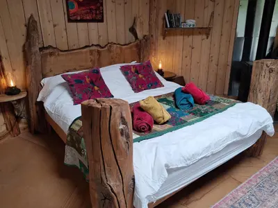 a bed with pillows on it in a room at Magical Offgrid Roundhouse in Eryri in Machynlleth