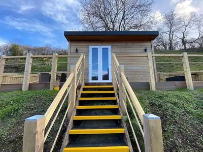 a tiny house with stairs leading to a door at Castle View chalet in Llangollen