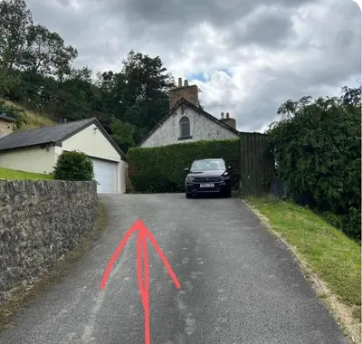 a car parked in a driveway with a x on the road at Castle View chalet in Llangollen