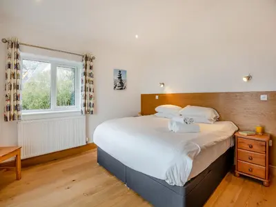 a bedroom with a large bed and a window at Bodwennol in Aberdyfi