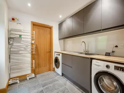 a kitchen with a washing machine and a washer at Bodwennol in Aberdyfi