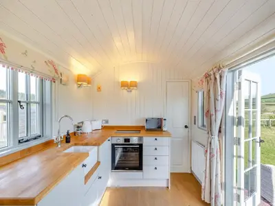 a kitchen with white cabinets and a large window at Sunflower - Uk42360 in Saint Harmon