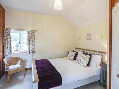 a bedroom with a bed and a chair and a window at The Old Coach House -Uk41272 in Great Hanwood
