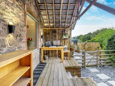 a patio with a wooden table and a building at The Lodge Spa - Uk47837 in Church Pulverbatch