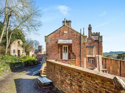 an old brick house on a brick wall at Apartment At Llanerchydol Hall in Welshpool